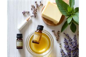 Składniki do domowych kosmetyków: masło shea, olejki eteryczne i świeże zioła, symbolizujące pielęgnację DIY zero waste.